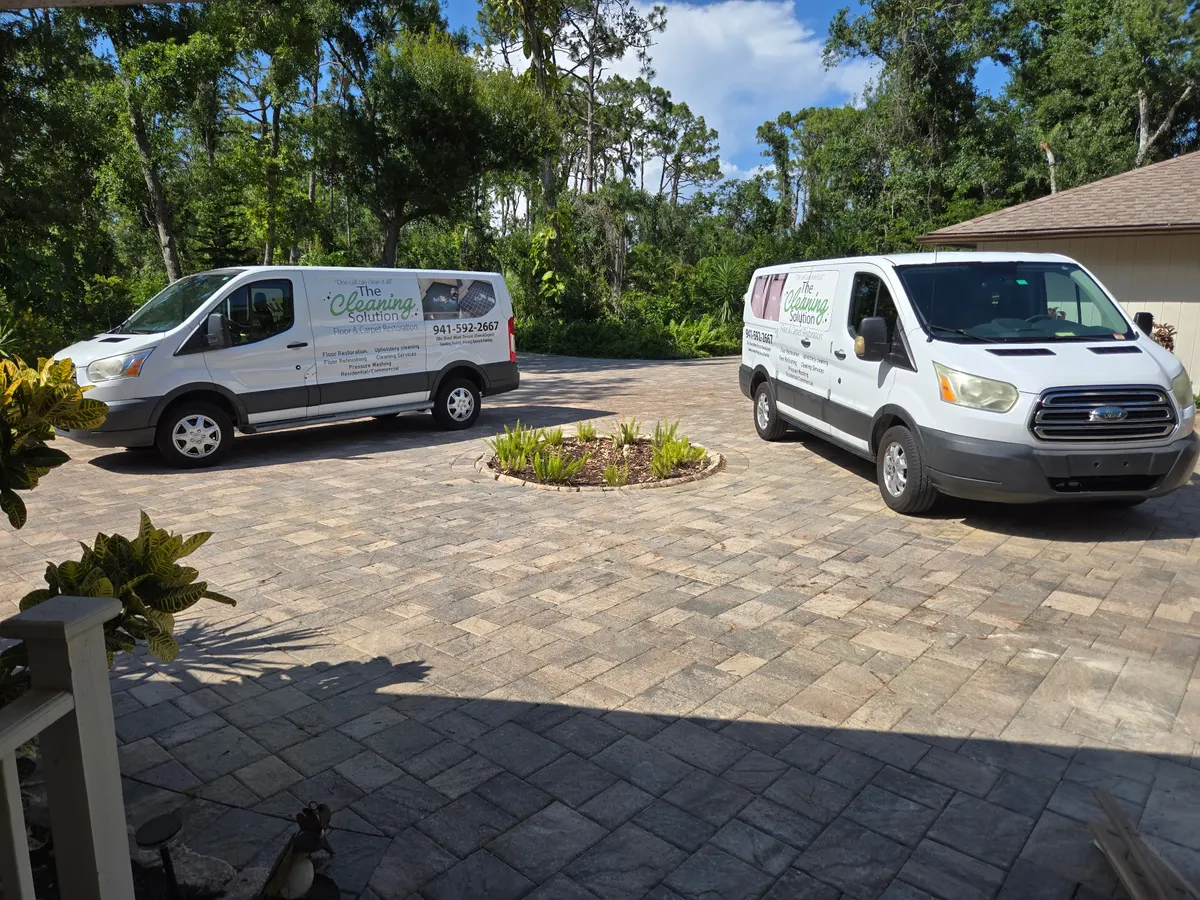 The Cleaning Solution crew vans on a brick paver driveway